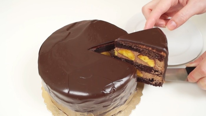 На фото банановый торт с шоколадом на тарелке