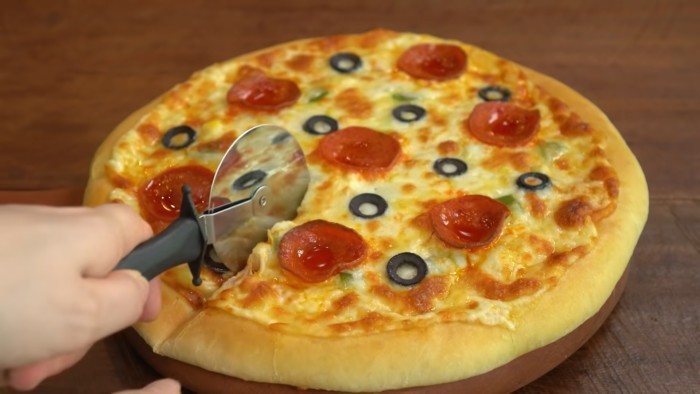 Режим готовую домашнюю пиццу на столе